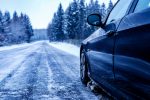 black-car-iced-road-surrounded-by-trees-covered-with-snow