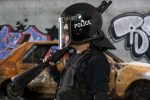 armed-police-with-riot-helmet-vest-scene-with-burnt-car-riots