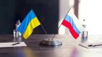 russian-ukrainian-flags-table-with-documents-pens-glasses-water