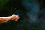 man-s-hand-holding-gun-with-dark-background