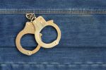 police-steel-handcuffs-lying-dark-blue-jeans-background