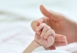 Μωρό κρατά το χέρι της μητέρας του
