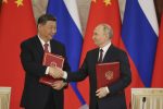 Russian President Vladimir Putin and Chinese President Xi Jinping shake hands
