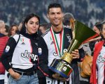 Cristiano Ronaldo holding the Serie A title trophy celebrates with his girlfriend Georgina Rodriguez