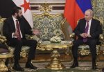 Russian President Vladimir Putin listens to Syrian President Ahmed al-Sharaa