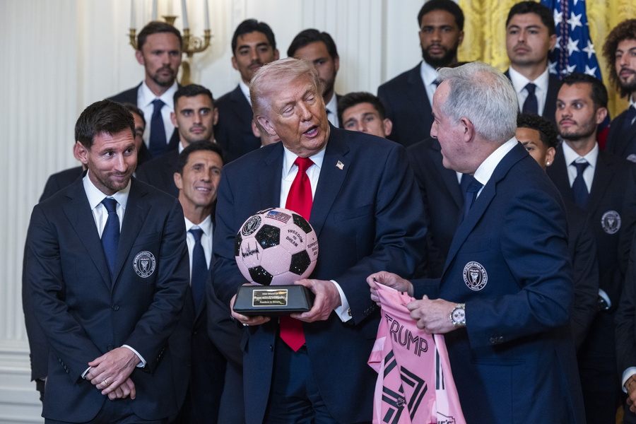 Inter Miami forward Lionel Messi (L) and the team's owner Jorge Mas (R) give US President Donald Trump
