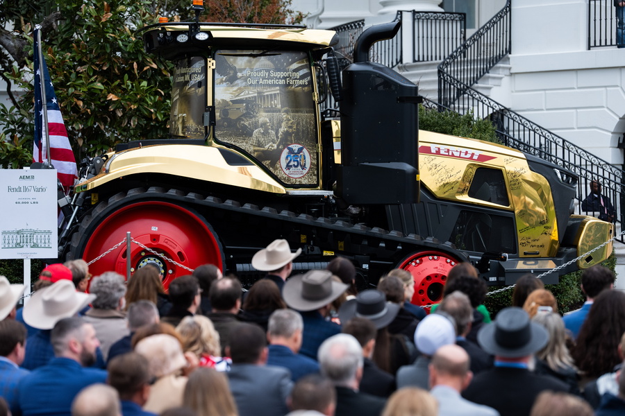A golden farming tractor featuring the signatures of Trump Administration