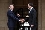 Cyprus President Nikos Christodoulides (R) shakes hands with French President Emmanuel Macron