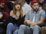 Taylor Swift (L) and Travis Kelce (R) watch from the sideline during