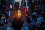 Crowds hope to see the sun align with the street grid in New York, New York, USA,