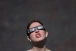 A person wears protective glasses during a partial solar eclipse, at the Royal Observatory Greenwich in